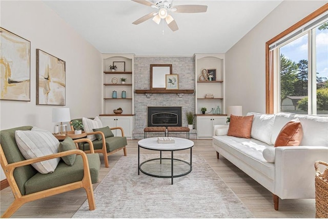 3203 Canterbury Cir, Saint Paul, MN 55125 - living room featuring a ceiling fan, light wood finished floors, a large fireplace, and built in shelves