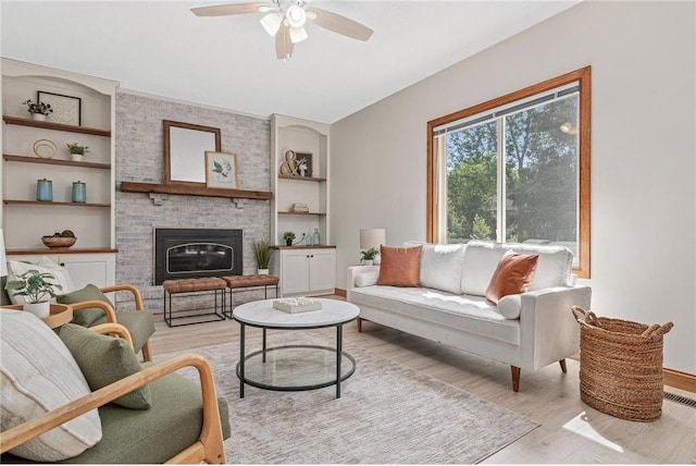 3203 Canterbury Cir, Saint Paul, MN 55125 - living room featuring light wood-style flooring, ceiling fan, built in features, and a fireplace