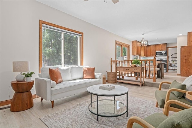 3203 Canterbury Cir, Saint Paul, MN 55125 - living room featuring light wood finished floors, a chandelier, a ceiling fan, and recessed lighting
