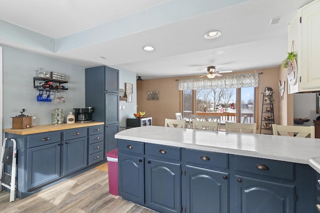 W6815 N Walworth Rd, Walworth, WI 53184 - kitchen featuring blue cabinets, light wood-type flooring, light countertops, ceiling fan, and recessed lighting