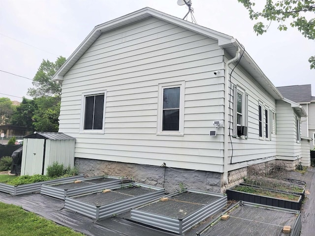 1425 Rogers St, Stevens Point, WI 54481 - view of property exterior featuring a garden, a storage shed, and uncovered parking