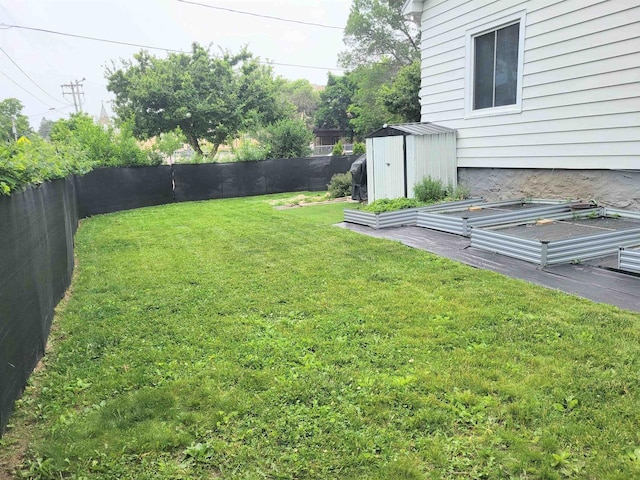 1425 Rogers St, Stevens Point, WI 54481 - fenced backyard featuring a vegetable garden and a storage unit