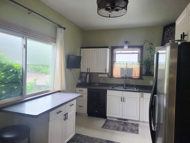 1425 Rogers St, Stevens Point, WI 54481 - kitchen with freestanding refrigerator, dishwasher, white cabinetry, and light tile patterned floors