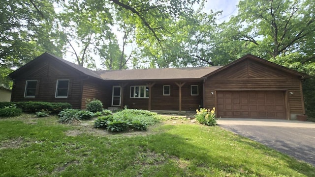519 Bird Rd, Twin Lakes, WI 53181 - view of front of home with an attached garage, asphalt driveway, and a front yard