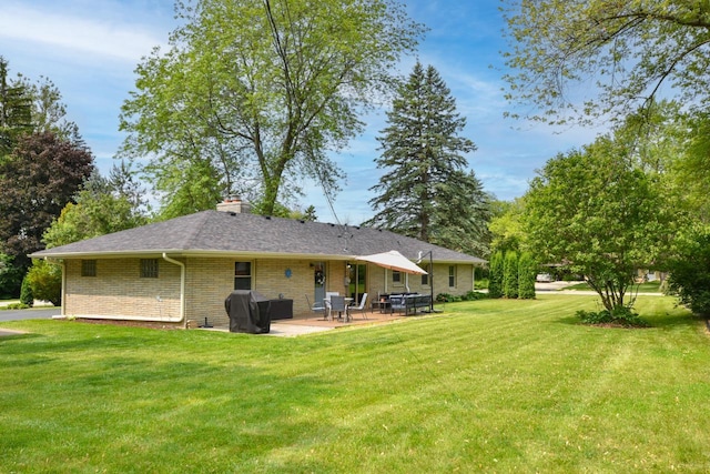 N68W15240 Prudence Dr, Menomonee Falls, WI 53051 - rear view of house with brick siding, a patio area, a yard, and a chimney