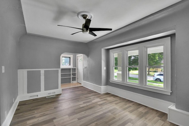 2863 N 38th St, Milwaukee, WI 53210 - empty room with arched walkways, wood finished floors, and a ceiling fan