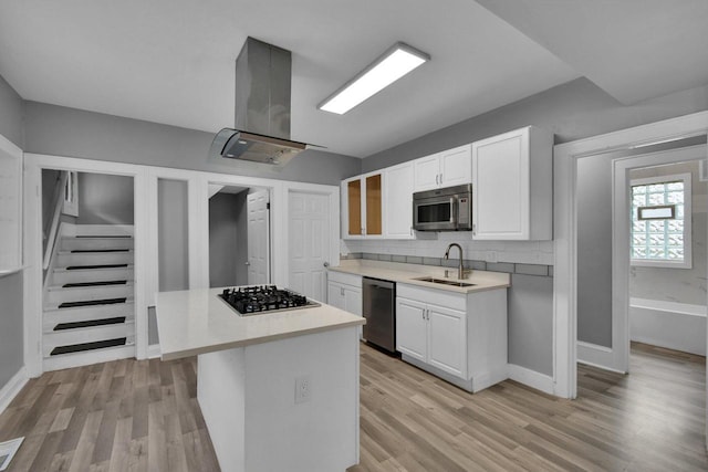 2863 N 38th St, Milwaukee, WI 53210 - kitchen with stainless steel appliances, island range hood, light wood-type flooring, and white cabinetry