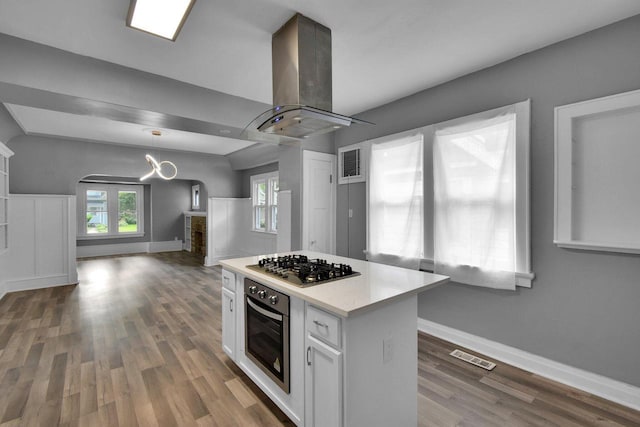 2863 N 38th St, Milwaukee, WI 53210 - kitchen with island range hood, oven, arched walkways, open floor plan, and white cabinets