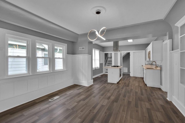 2863 N 38th St, Milwaukee, WI 53210 - unfurnished living room with dark wood-type flooring, stairs, a wainscoted wall, and a chandelier
