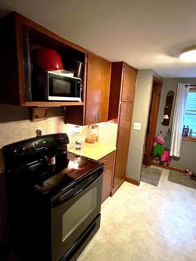 3151 Reddin Rd, Wisconsin Rapids, WI 54495 - kitchen with black appliances, tasteful backsplash, and brown cabinetry