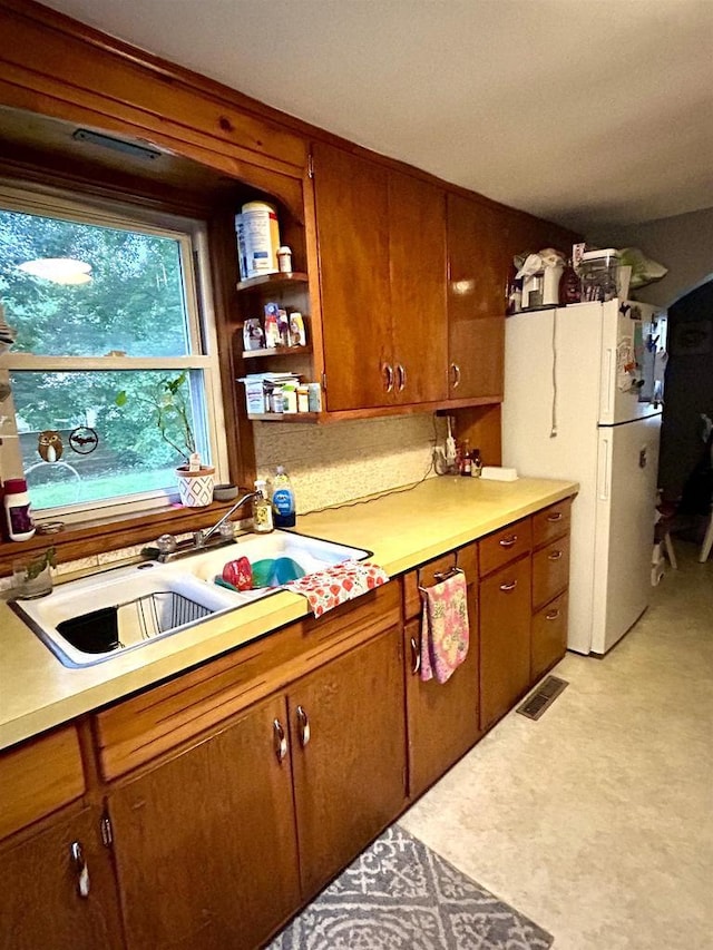 3151 Reddin Rd, Wisconsin Rapids, WI 54495 - kitchen with freestanding refrigerator, light countertops, and brown cabinetry