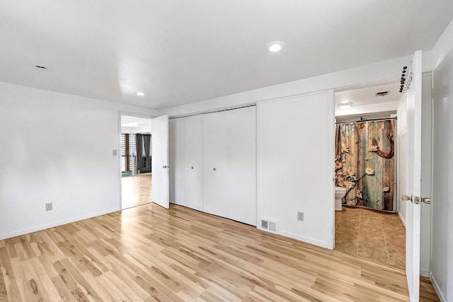11975 E Anderson Lake Dr, Suring, WI 54174 - unfurnished bedroom featuring light wood-style floors, recessed lighting, connected bathroom, and a closet