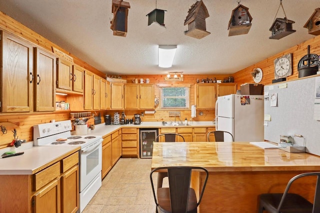 7454 State Highway 186, Arpin, WI 54410 - kitchen with white appliances, beverage cooler, a kitchen breakfast bar, wooden walls, and a textured ceiling