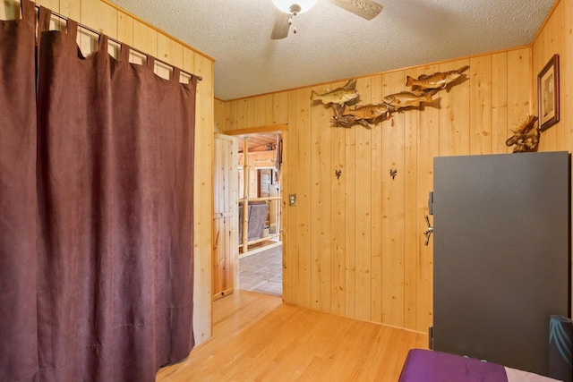 7454 State Highway 186, Arpin, WI 54410 - workout area with wooden walls, a textured ceiling, light wood-style floors, and ceiling fan