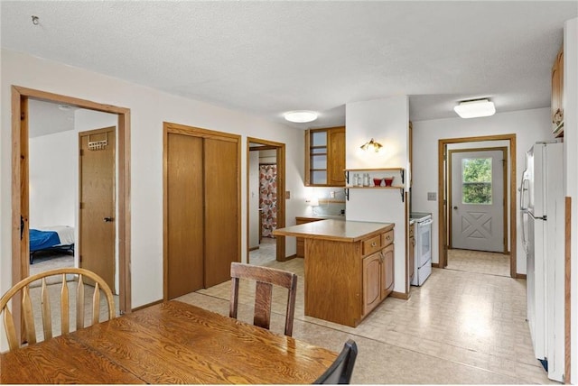1231 135th St, Amery, WI 54005 - kitchen with a peninsula, white appliances, brown cabinets, and light countertops