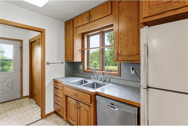1231 135th St, Amery, WI 54005 - kitchen with freestanding refrigerator, dishwasher, brown cabinets, and light floors