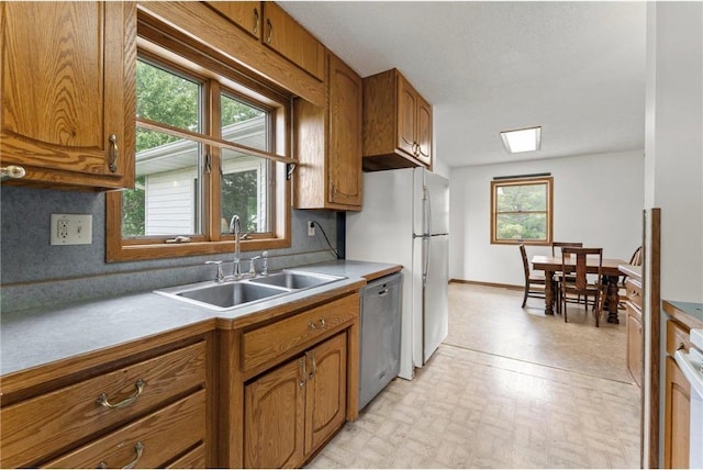 1231 135th St, Amery, WI 54005 - kitchen featuring dishwasher, brown cabinetry, healthy amount of natural light, and light countertops