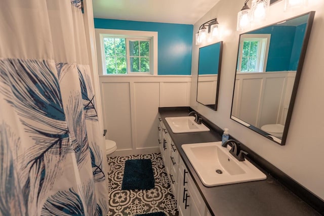 N3342 Hickory Rd, Lake Geneva, WI 53147 - full bathroom featuring plenty of natural light, double vanity, a decorative wall, wainscoting, and tile patterned flooring