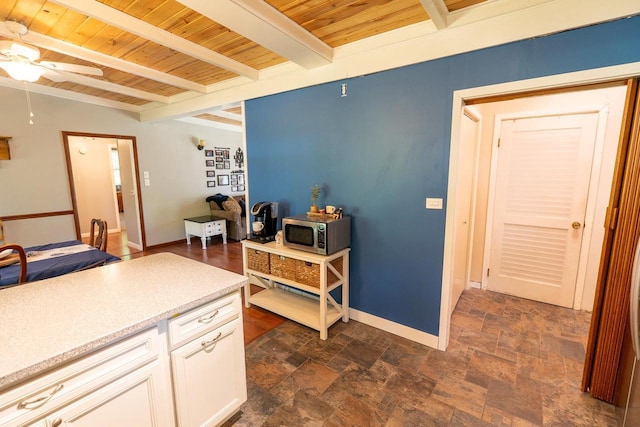 N3342 Hickory Rd, Lake Geneva, WI 53147 - kitchen featuring stainless steel microwave, a wooden ceiling with exposed beams, ceiling fan, dark stone finish flooring, and light countertops