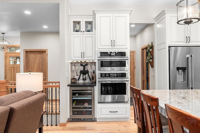 4140 N Prairie Rose Ln, Appleton, WI 54913 - kitchen featuring stainless steel appliances, beverage cooler, light wood-style floors, white cabinets, and backsplash