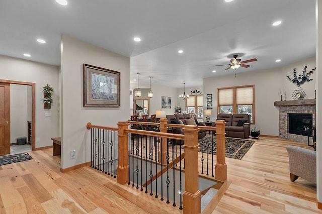4140 N Prairie Rose Ln, Appleton, WI 54913 - staircase featuring wood finished floors, a ceiling fan, recessed lighting, a glass covered fireplace, and a chandelier