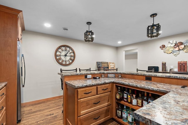 4140 N Prairie Rose Ln, Appleton, WI 54913 - kitchen featuring brown cabinetry, freestanding refrigerator, light wood finished floors, hanging light fixtures, and recessed lighting