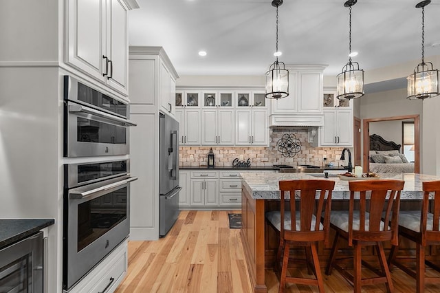 4140 N Prairie Rose Ln, Appleton, WI 54913 - kitchen with stainless steel appliances, beverage cooler, a breakfast bar, light wood-style floors, and tasteful backsplash