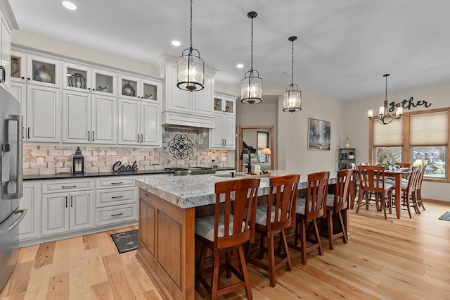 4140 N Prairie Rose Ln, Appleton, WI 54913 - kitchen with high end fridge, tasteful backsplash, light wood-style floors, recessed lighting, and a center island with sink