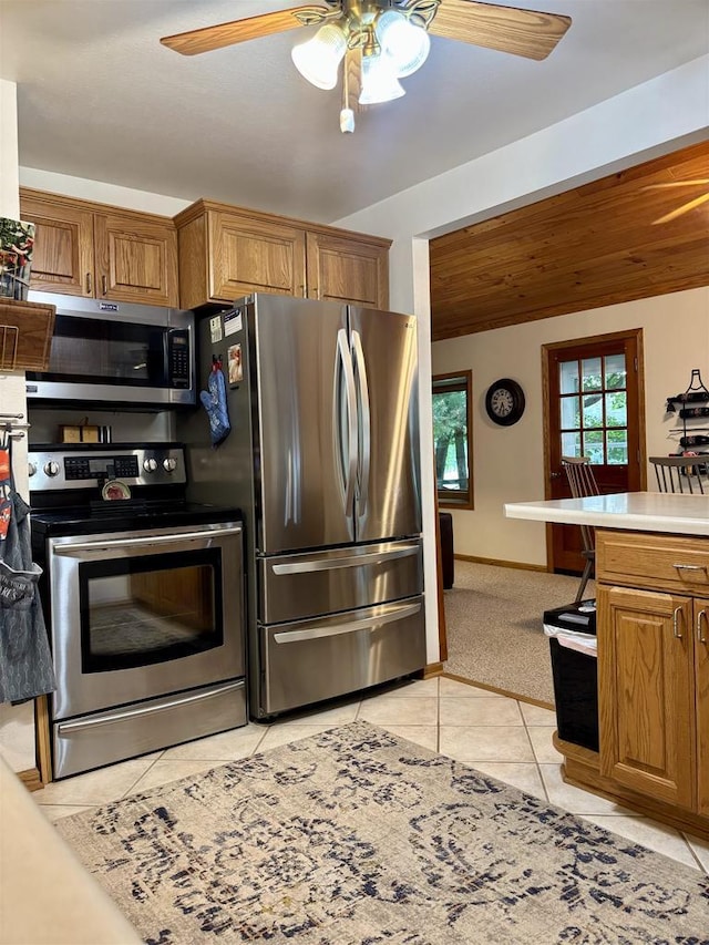 N3911 Lakeside Ln, Wautoma, WI 54982 - kitchen with stainless steel appliances, ceiling fan, brown cabinets, light tile patterned floors, and light countertops
