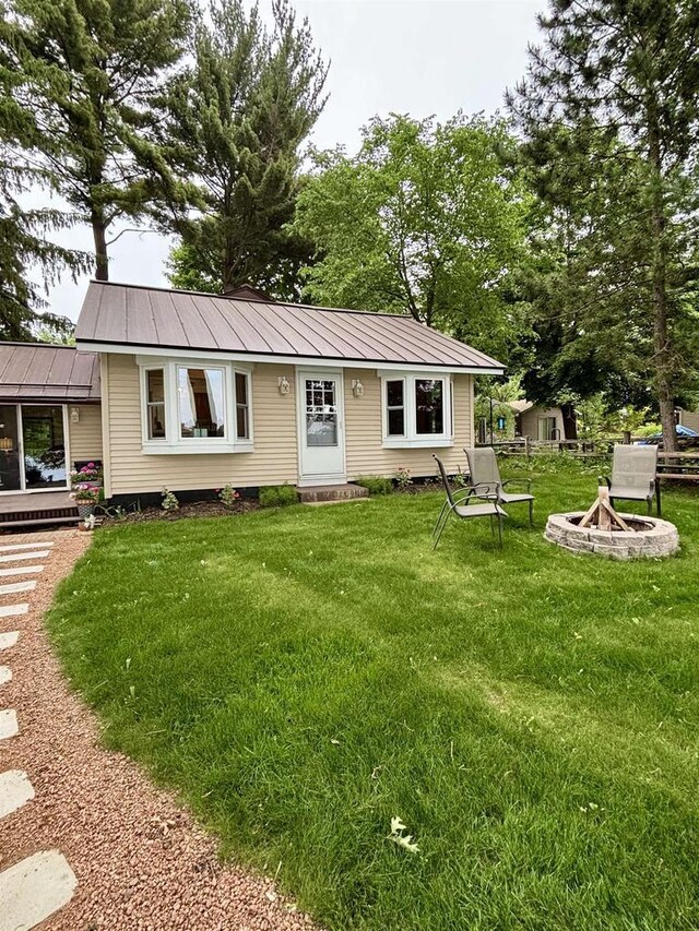N3911 Lakeside Ln, Wautoma, WI 54982 - view of front of property with a fire pit, a front lawn, a metal roof, and entry steps