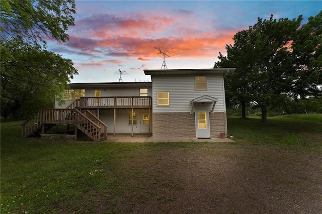 1231 135th St, Amery, WI 54001 - back of house featuring stairs, a deck, stone siding, a patio area, and a lawn