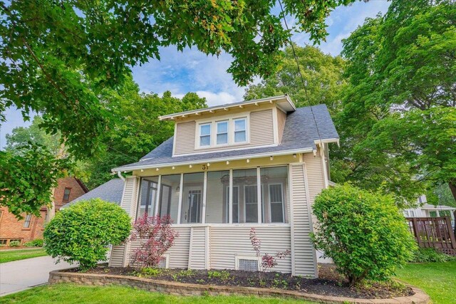 31 Elm St, Fort Atkinson, WI 53538 - view of front of home with a sunroom, roof with shingles, and a front lawn