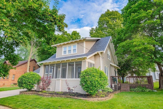31 Elm St, Fort Atkinson, WI 53538 - view of front of house featuring a sunroom, a deck, a front yard, and roof with shingles