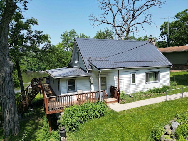 9317 N Arrowhead Shores Rd, Edgerton, WI 53534 - view of front of home with a deck, a front yard, a metal roof, stairway, and a chimney