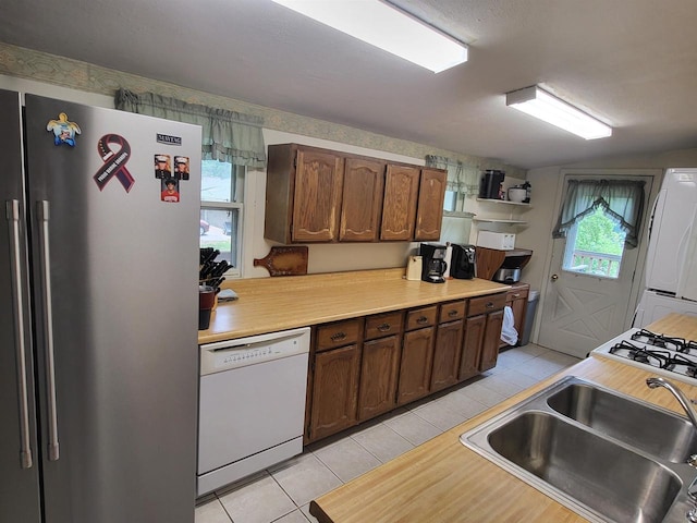9317 N Arrowhead Shores Rd, Edgerton, WI 53534 - kitchen with freestanding refrigerator, white dishwasher, light tile patterned floors, and light countertops