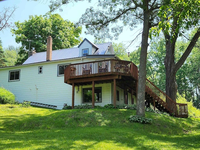 9317 N Arrowhead Shores Rd, Edgerton, WI 53534 - back of house featuring a wooden deck, a chimney, stairs, a lawn, and a metal roof