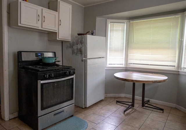 5136 N 42nd St, Milwaukee, WI 53209 - kitchen with stainless steel range with gas cooktop, freestanding refrigerator, white cabinets, light tile patterned floors, and crown molding