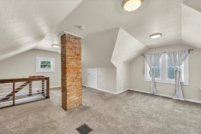 904 Romayne Ave, Racine, WI 53402 - additional living space with a textured ceiling, ornate columns, carpet, vaulted ceiling, and plenty of natural light