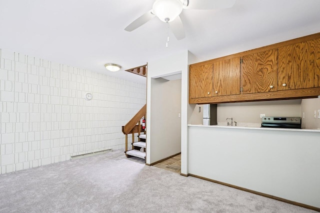 W166N9162 Grand Ave Unit 2, Menomonee Falls, WI 53051 - kitchen with appliances with stainless steel finishes, brown cabinetry, carpet flooring, and ceiling fan