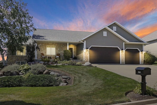 329 S Stone Ridge Dr, Lake Geneva, WI 53147 - view of front of home with stone siding, an attached garage, concrete driveway, and a lawn