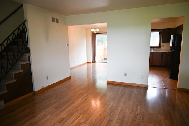 5905-5907 Rattman Rd, Madison, WI 53718 - unfurnished living room with stairway, a chandelier, and wood finished floors