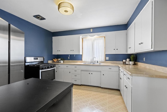 914 W 5th Ave, Oshkosh, WI 54902 - kitchen with stainless steel appliances, white cabinets, light flooring, and light countertops