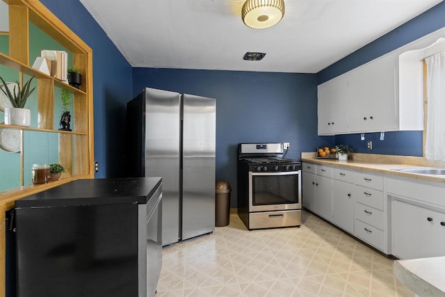 914 W 5th Ave, Oshkosh, WI 54902 - kitchen with appliances with stainless steel finishes, white cabinets, light floors, open shelves, and light countertops