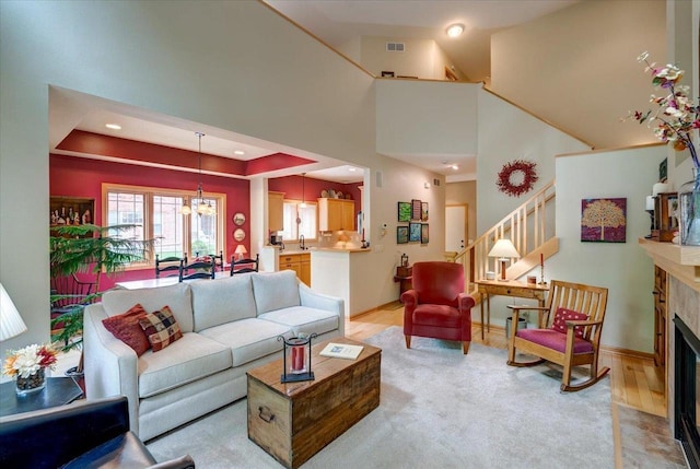 14 Wood Brook Way, Fitchburg, WI 53711 - living area with a chandelier, a fireplace with flush hearth, stairway, a high ceiling, and recessed lighting