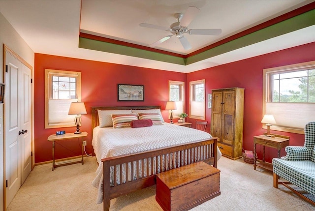 14 Wood Brook Way, Fitchburg, WI 53711 - carpeted bedroom with multiple windows, a tray ceiling, and a ceiling fan