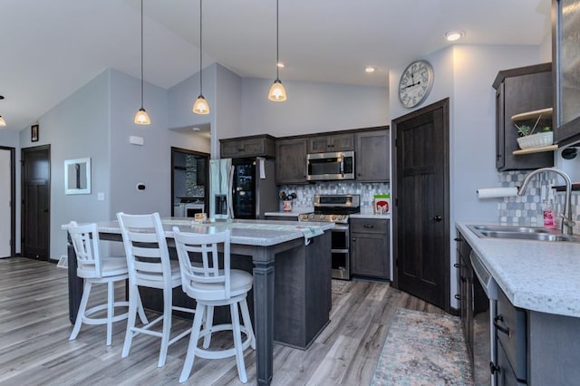 8810 Hinner Springs Dr, Weston, WI 54476 - kitchen with stainless steel appliances, a kitchen island, tasteful backsplash, light wood-style flooring, and high vaulted ceiling