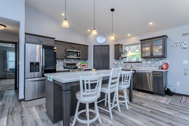8810 Hinner Springs Dr, Weston, WI 54476 - kitchen with appliances with stainless steel finishes, light countertops, dark brown cabinetry, light wood-style floors, and backsplash