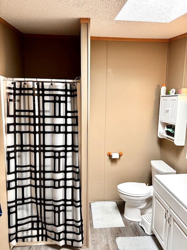 691 Valley Trl, Nekoosa, WI 54457 - full bathroom with wood finished floors, vanity, curtained shower, and a textured ceiling