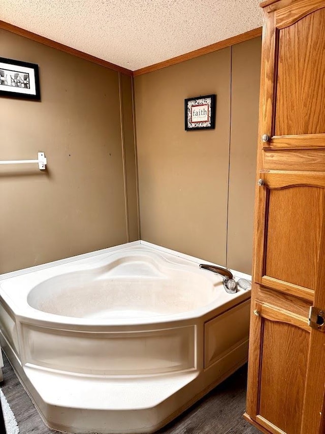 691 Valley Trl, Nekoosa, WI 54457 - full bathroom featuring a textured ceiling, wood finished floors, crown molding, and a garden tub