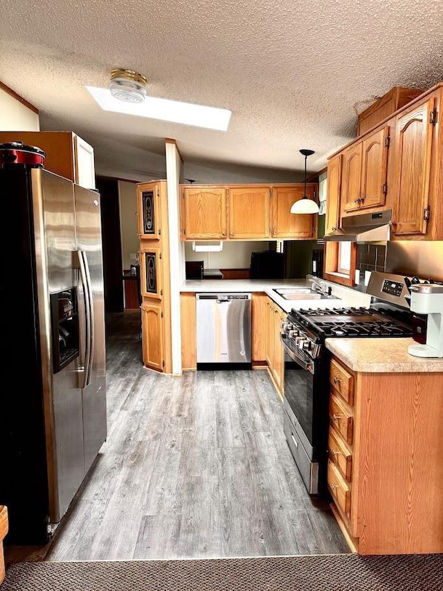 691 Valley Trl, Nekoosa, WI 54457 - kitchen featuring stainless steel appliances, under cabinet range hood, light wood-style floors, a textured ceiling, and light countertops